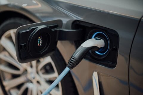Elektrofahrzeug an E-Ladesäule mit eingestecktem Ladestecker
